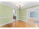 Dining room featuring hardwood floors, elegant chandelier, and soft green walls adjacent to the kitchen at 5424 Westminster Ln, Fuquay Varina, NC 27526