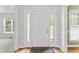Bright front door with sidelights and transom window, complemented by fresh white trim and a wooden floor at 5424 Westminster Ln, Fuquay Varina, NC 27526