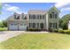 Inviting two-story home showcasing a two-car garage and manicured front lawn and landscaping at 5424 Westminster Ln, Fuquay Varina, NC 27526
