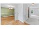 Hallway with hardwood and carpet floors, white wainscoting, and an inviting view into the dining room at 5424 Westminster Ln, Fuquay Varina, NC 27526