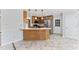 Bright kitchen with stainless steel refrigerator, wooden cabinets, breakfast bar, and door to backyard at 5424 Westminster Ln, Fuquay Varina, NC 27526