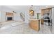 Open kitchen with wooden cabinetry, stainless steel appliances, and breakfast bar overlooks living room with fireplace at 5424 Westminster Ln, Fuquay Varina, NC 27526