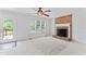 Living room featuring brick fireplace, neutral carpet, ceiling fan, and a door leading to the outdoor deck at 5424 Westminster Ln, Fuquay Varina, NC 27526