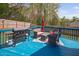 Outdoor back deck with a grill, seating area, umbrella, and blue flooring for entertaining and relaxation at 556 Rolling Meadows Dr, Clayton, NC 27527