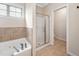 Elegant bathroom featuring a luxurious soaking tub, walk-in shower, and tiled walls at 556 Rolling Meadows Dr, Clayton, NC 27527