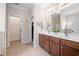 Well-lit bathroom with double vanities, tile floors, and walk-in closet at 556 Rolling Meadows Dr, Clayton, NC 27527