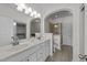 Modern bathroom featuring double sinks, sleek cabinetry, and an arched entry to the tiled shower and toilet area at 5702 Cameo Glass Way, Raleigh, NC 27612