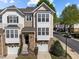 Charming townhome featuring a stone facade, attached garage, and a well-maintained lawn at 5702 Cameo Glass Way, Raleigh, NC 27612