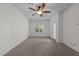 Living room featuring neutral walls, carpeted floor, a ceiling fan, a window, and a glass panel door to the outside at 5702 Cameo Glass Way, Raleigh, NC 27612