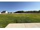 Large, flat backyard with a new home construction in the distance with vibrant green grass at 61 Heatherglenn Cir, Princeton, NC 27569