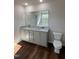 Bathroom with double sink vanity, granite countertop, a large mirror, and wood look flooring at 61 Heatherglenn Cir, Princeton, NC 27569
