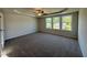 Spacious primary bedroom featuring a tray ceiling, plush carpet, and ample natural light at 61 Heatherglenn Cir, Princeton, NC 27569