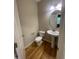 Half bath featuring hardwood floors, pedestal sink and modern lighting at 66 Saddle Ln, Lillington, NC 27546