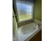 Bathroom featuring a tub with tile surround and frosted window at 66 Saddle Ln, Lillington, NC 27546