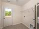 Bright laundry room with tile floors, a utility sink, and a door to the outside at 67 Fern Ridge Dr, Cameron, NC 28326