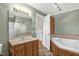 Bathroom with a vanity, mirror, bathtub, and view into the next room at 6702 Huntsboro Rd, Oxford, NC 27565