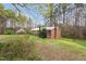 Quaint brick home featuring a chimney, partially wooded lot and fresh green lawn at 6702 Huntsboro Rd, Oxford, NC 27565