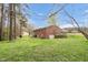 Exterior view of the brick home's backyard and deck at 6702 Huntsboro Rd, Oxford, NC 27565