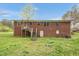 Exterior view of the back of the brick home, showcasing a staircase and small doorway at 6702 Huntsboro Rd, Oxford, NC 27565
