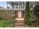 Close-up of a home's front entrance featuring brick steps, black iron railing, and a white front door at 6702 Huntsboro Rd, Oxford, NC 27565