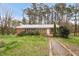 Charming single-story brick home with a well-kept lawn, mature trees, and inviting front entrance at 6702 Huntsboro Rd, Oxford, NC 27565