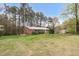 A well-maintained home sits amongst mature trees and manicured shrubs on a vast green lawn at 6702 Huntsboro Rd, Oxford, NC 27565