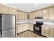 Kitchen with light-colored cabinets, tile flooring, and stainless steel refrigerator at 6702 Huntsboro Rd, Oxford, NC 27565