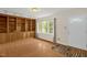 Living room featuring wood floors, built-in shelves and cabinets, and a large window overlooking the yard at 6702 Huntsboro Rd, Oxford, NC 27565