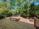 Spacious wooden back deck with a bench and black iron railings surrounded by mature trees at 6909 Clear Sailing Ln, Raleigh, NC 27615