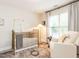 Comfortable Bedroom featuring a classic crib, soft lighting, and a cozy chair at 6909 Clear Sailing Ln, Raleigh, NC 27615