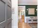 View of foyer leading to kitchen with stylish green accent wall, chandelier, and hardwood floors at 6909 Clear Sailing Ln, Raleigh, NC 27615