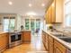 Well-lit kitchen featuring natural wood cabinetry, stainless steel appliances, and a connected breakfast area at 6909 Clear Sailing Ln, Raleigh, NC 27615