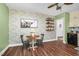 Eat in kitchen area with wood floors, green walls, brick accent wall, and a white ceiling fan at 7110 Hunter Hill Rd, Rocky Mount, NC 27804