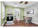 Eat in kitchen area with wood floors, green walls, brick accent wall, and a white ceiling fan at 7110 Hunter Hill Rd, Rocky Mount, NC 27804