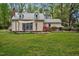 Charming home with metal roof, dormers, and purple doors nestled among trees at 7110 Hunter Hill Rd, Rocky Mount, NC 27804