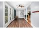 Hallway with wood floors, white trim, glass paneled doors, and a rattan chair at 7110 Hunter Hill Rd, Rocky Mount, NC 27804