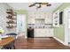 Kitchen with wood floors, green walls, brick accent wall, and white cabinets at 7110 Hunter Hill Rd, Rocky Mount, NC 27804