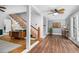 Living room with wood floors, stairs with wood railing, white trim, and a ceiling fan at 7110 Hunter Hill Rd, Rocky Mount, NC 27804