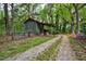 Outbuilding with corrugated siding and a simple shed roof along a gravel driveway at 7110 Hunter Hill Rd, Rocky Mount, NC 27804