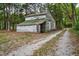 Weathered outbuilding with faded white siding and a green shed roof near a dirt path at 7110 Hunter Hill Rd, Rocky Mount, NC 27804