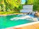 Backyard swimming pool featuring a waterfall and a pool house on a large, well-maintained lawn at 7110 Hunter Hill Rd, Rocky Mount, NC 27804