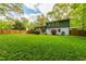 The well-manicured backyard features a lush lawn, mature trees, and a charming deck for outdoor relaxation and enjoyment at 7409 Fiesta Way, Raleigh, NC 27615