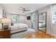 A serene bedroom featuring natural light, a ceiling fan, a television, and hardwood floors at 7409 Fiesta Way, Raleigh, NC 27615
