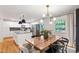 Open dining room showcasing a modern light fixture, a wood table, and white walls at 7409 Fiesta Way, Raleigh, NC 27615