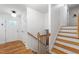 A warm entryway leading to stairs and a front door, showcasing hardwood floors and natural light at 7409 Fiesta Way, Raleigh, NC 27615