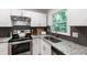 Modern kitchen featuring stainless steel appliances, granite countertops, and stylish backsplash at 7409 Fiesta Way, Raleigh, NC 27615