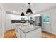 Well-lit kitchen with white cabinetry, stainless steel appliances, and an island, offering a modern and functional space at 7409 Fiesta Way, Raleigh, NC 27615