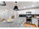 Bright kitchen with white cabinets, stainless appliances, and a gray granite island perfect for food prep at 7409 Fiesta Way, Raleigh, NC 27615