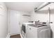 Functional laundry room with modern washer and dryer units, ample lighting, and convenient access to the exterior at 7409 Fiesta Way, Raleigh, NC 27615