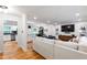 Open-concept living area featuring hardwood floors, a stylish sofa, and a seamless flow into the dining and kitchen spaces at 7409 Fiesta Way, Raleigh, NC 27615